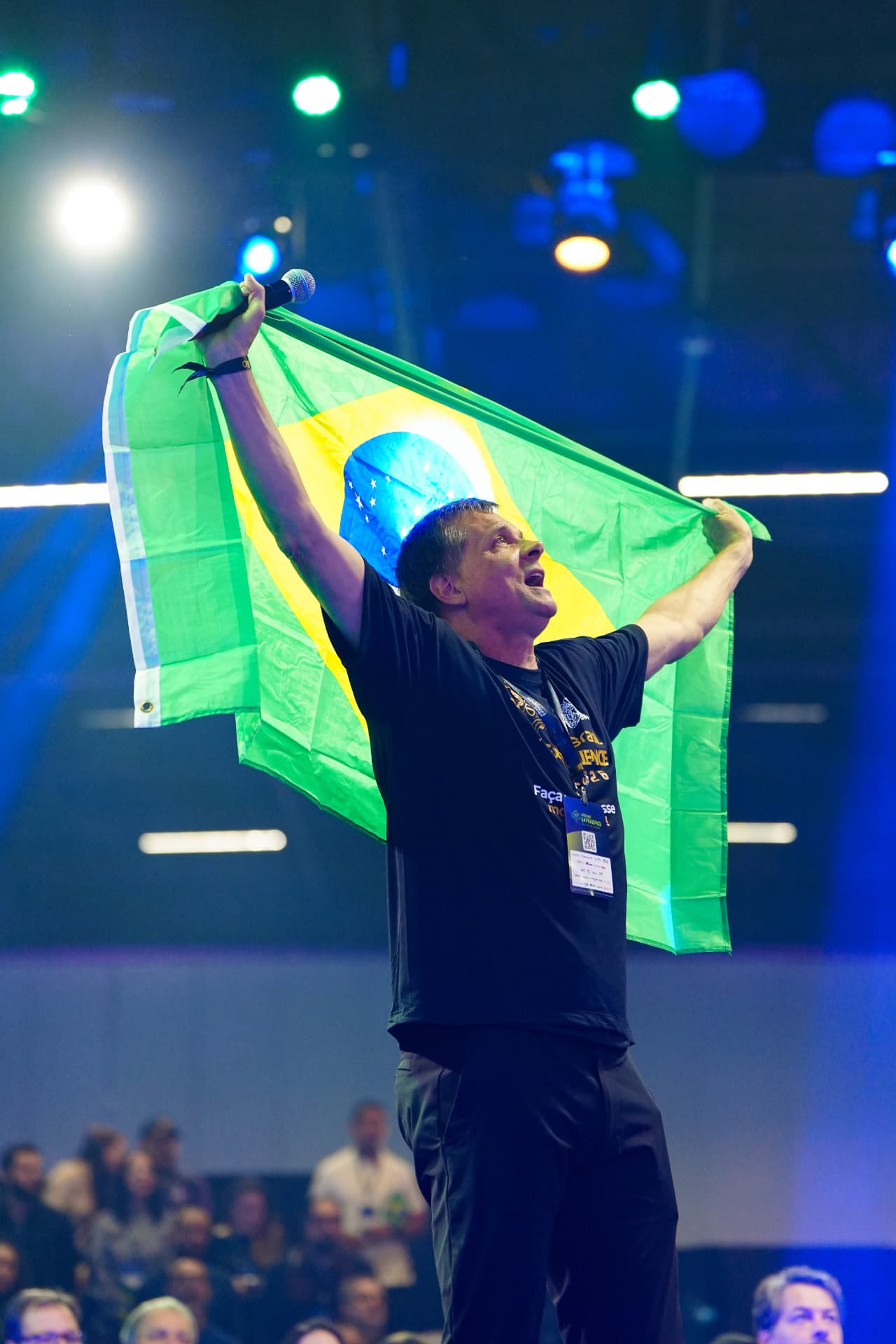 Palestrante com a bandeira do Brasil no palco do AI Brasil Experience