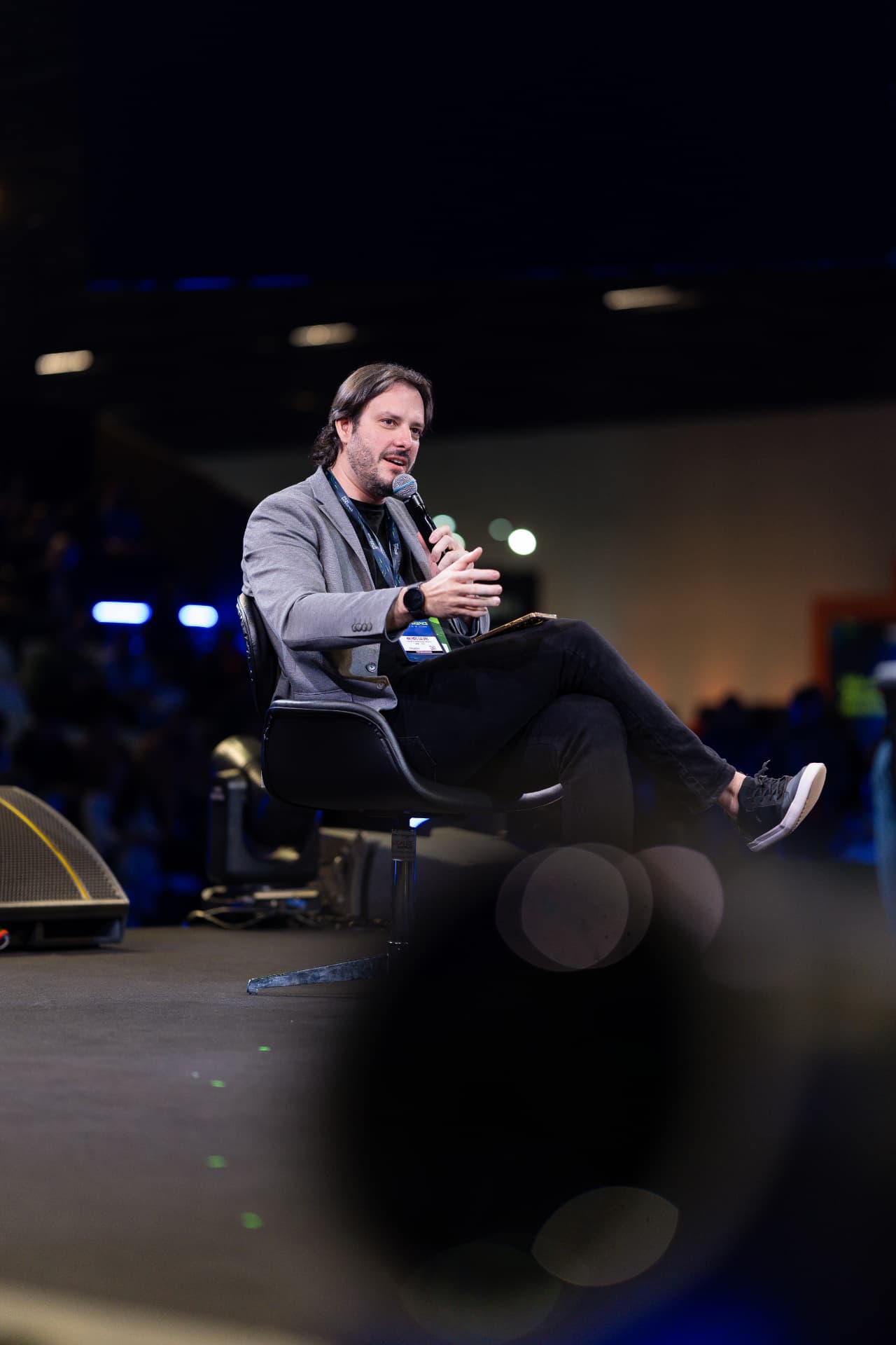 Palestrante durante painel sentado no palco do AI Brasil Experience
